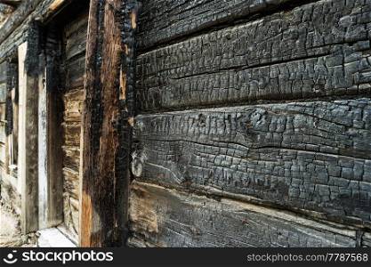 Charred black wooden wall. Angle Image of a burned boards of slum house closeup. Charred black wooden wall. Angle Image of a burned boards of slum house