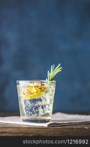 Charred Lemon, Rosemary and Coriander Gin and Tonic is a flavors are perfectly balanced refreshing cocktail. on dark background, close up. Summer drinks and alcoholic or detox cocktail