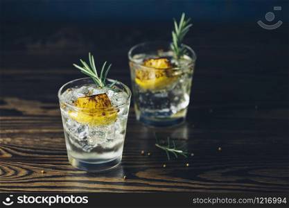 Charred Lemon, Rosemary and Coriander Gin and Tonic is a flavors are perfectly balanced refreshing cocktail. on dark background, close up. Summer drinks and alcoholic or detox cocktail
