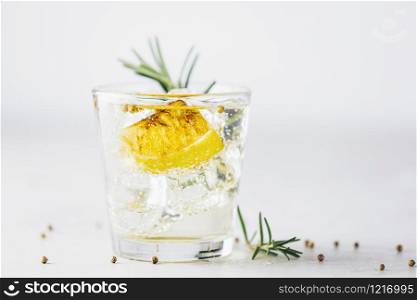 Charred Lemon, Rosemary and Coriander Gin and Tonic is a flavors are perfectly balanced refreshing cocktail. on light background, close up. Summer drinks and alcoholic or detox cocktail