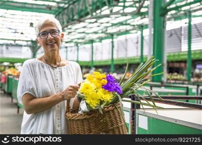 Charrming senior woman buying  flowers on local market