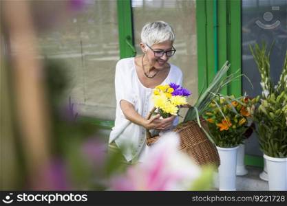 Charrming senior woman buying  flowers on local market
