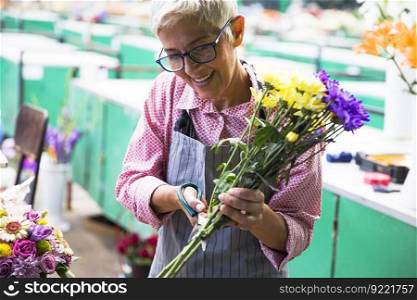 Charrming senior woman sales flowers on local market