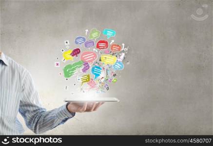 Chat online. Close up of hand holding tablet pc with speech bubbles