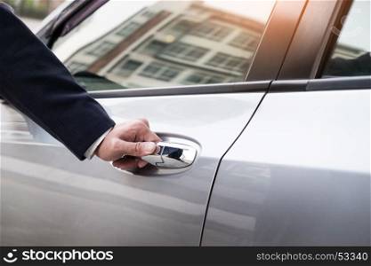 Chauffeur s hand on handle. Close-up of man in formal wear opening a passenger car door.