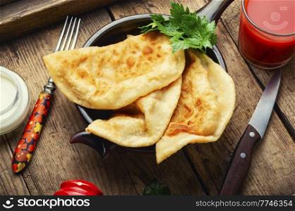 Cheburek, a dish of unleavened dough stuffed with minced meat. Crimean Tatar cuisine. Fried pies with meat filling