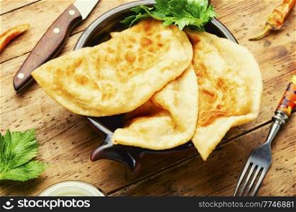 Chebureks, fried crescent-shaped pie with meat filling. A popular and traditional dish of Greek and Tatar cuisine.. Non-yeast dough pies with meat filling