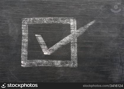 Check box with a tick drawn in chalk on a blackboard