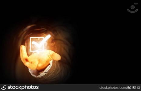 Check tick icon. Close up of businessman&rsquo;s hand holding check mark icon in palm