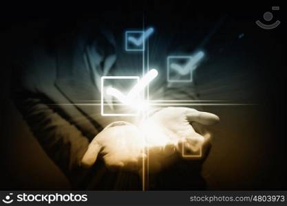Checkbox tick. Close up of businessman holding icons in palms