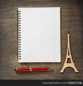 checked notebook and pen. checked notebook and pen at wooden background
