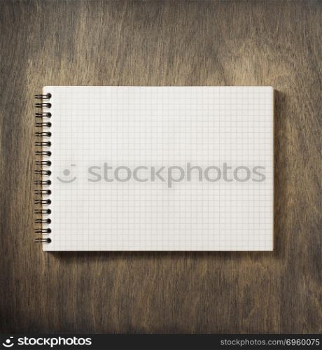 checked notebook at wood. checked notebook at wooden background