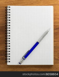 checked notebook on wood background