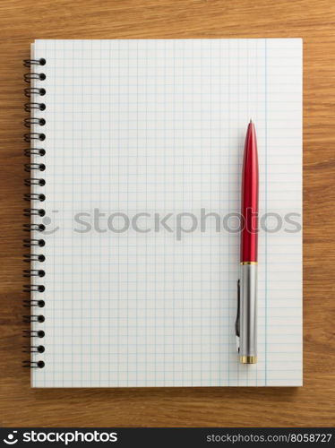 checked notebook on wood background