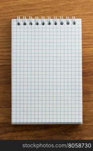 checked notebook on wood background