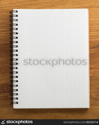 checked notebook on wood background