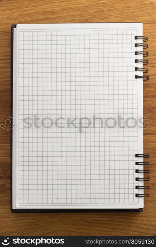 checked notebook on wood background