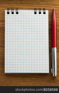 checked notebook on wooden background