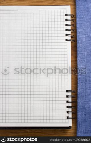 checked notebook on wooden background