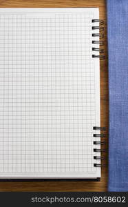 checked notebook on wooden background