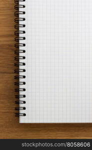 checked notebook on wooden background