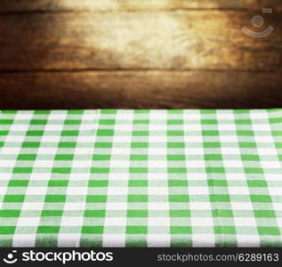 Checkered green tablecloth over rustic wooden background