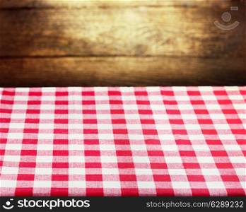 Checkered red tablecloth over rustic wooden background