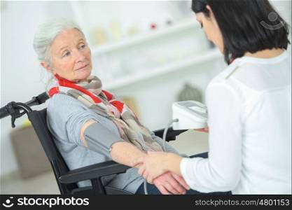 Checking an old lady's blood pressure