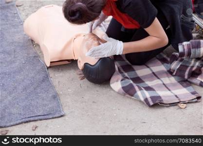 Checking heart rate. Female instructor showing cardiopulmonary resuscitation - CPR on training dummy. First aid training.