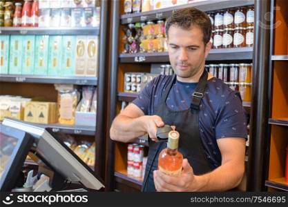 Checkout clerk scanning bottle of wine
