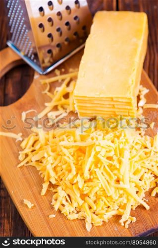 cheddar cheese on board and on a table