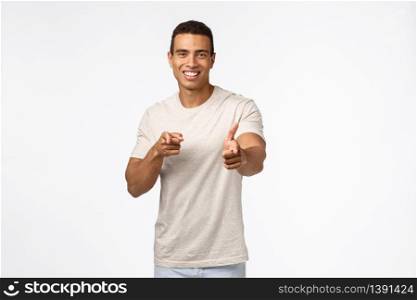 Cheeky friendly handsome musculine young tanned strong man, pointing camera and smiling, praise you good job, congratulate person with achievement, standing white background happy.. Cheeky friendly handsome musculine young tanned strong man, pointing camera and smiling, praise you good job, congratulate person with achievement, standing white background happy