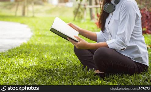 cheerful and lifestyle concept, joyful woman reading a book on glass in the outdoor garden.