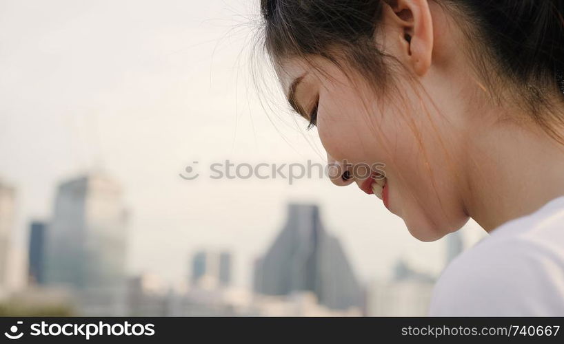 Cheerful Asian tourist blogger woman using smartphone for direction and looking on location map while traveling on the street at downtown city. Lifestyle backpack tourist travel holiday concept.