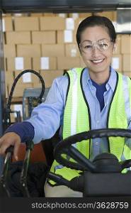 Cheerful Asian woman working in distribution warehouse