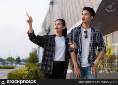 Cheerful Asian young man and woman dating at shopping mall, They talking, smile and laugh together with happiness, New normal lifestyle 