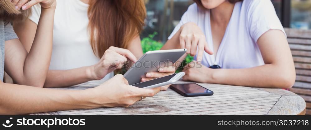 Cheerful asian young women sitting in cafe drinking coffee with . Cheerful asian young women sitting in cafe drinking coffee with friends and talking together. Attractive asian woman enjoying coffee while using smartphone for talking, reading and texting.