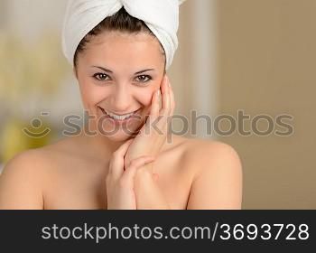 Cheerful attractive young girl smiling wrapped in towel
