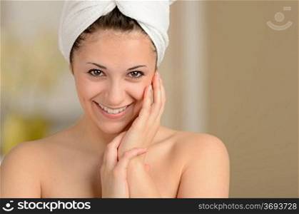 Cheerful attractive young girl smiling wrapped in towel