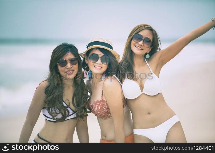 cheerful beautiful asian woman wearing swimsuit toothy smiling face happiness at seaside