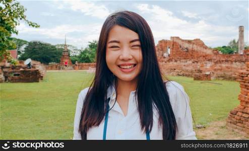 Cheerful beautiful young Asian backpacker blogger woman casual with camera take photo smiling traveling around pagoda at the old city, Lifestyle backpack tourist travel holiday concept. Point of view.
