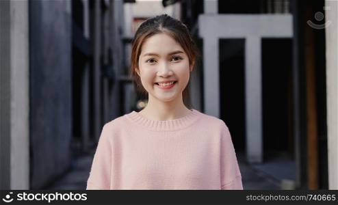 Cheerful beautiful young Asian woman feeling happy smiling to camera while traveling at Chinatown in Beijing, China. Lifestyle backpack tourist travel holiday concept. Portrait looking at camera.