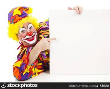 Cheerful birthday clown pointing at a blank sign. Isolated on white.