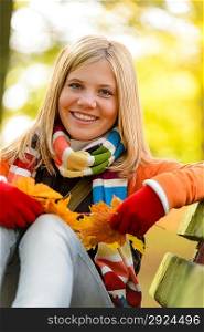 Cheerful blonde young girl sitting park fall colorful scarf autumn