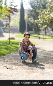 Cheerful boy wearing casual clothes while posing at city park