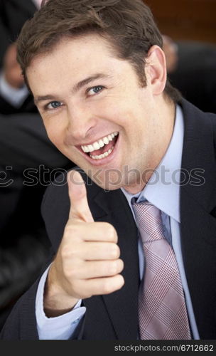 cheerful business man with his thumb up in his office