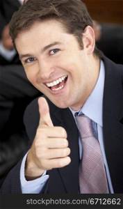 cheerful business man with his thumb up in his office