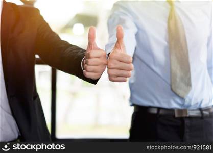 Cheerful business team giving thumbs up
