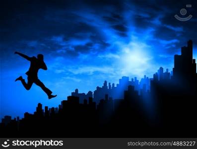 Cheerful businessman. Silhouette of businessman jumping against sunset background