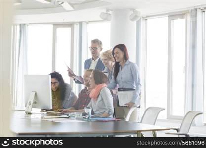 Cheerful businesspeople working together at conference table